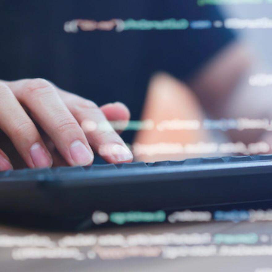 close up computer programmer man hand typing configuration on keyboard at laptop for input coding language to software for fix bug and defect of system in data center room , engineering and technology
